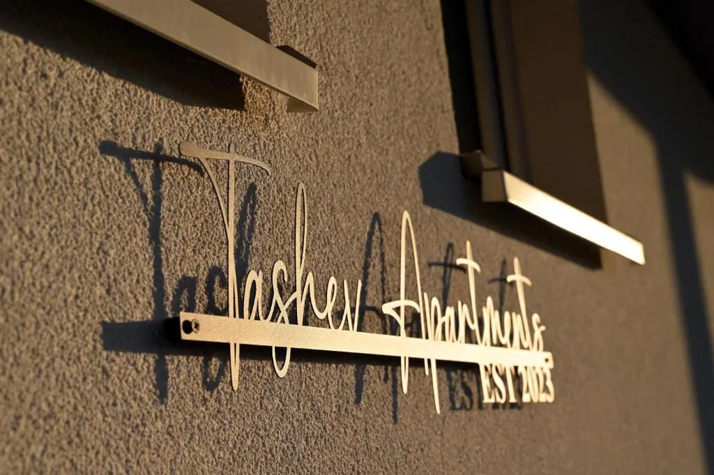 Tashev Apartments brass sign on the facade